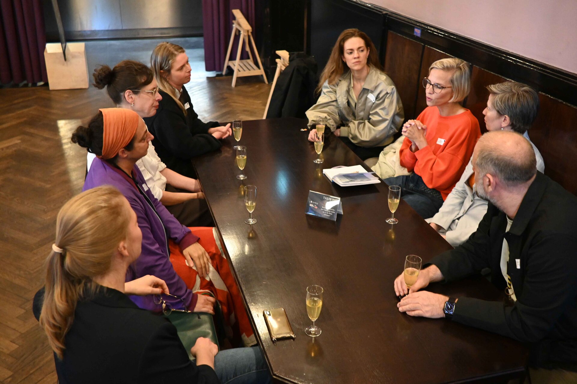 Menschen sitzen am Tisch und tauschen sich aus