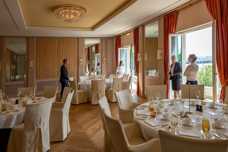 Elegantes Hotel-Restaurant mit gedeckten Tischen und Gästen.