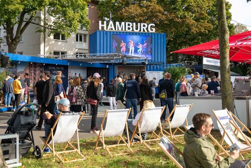 Menschenmenge vor dem Hamburg Stand mit Sitzmöglichkeiten. Impressionen vom Bürgerfest zum Tag der Deutschen in Bremen.