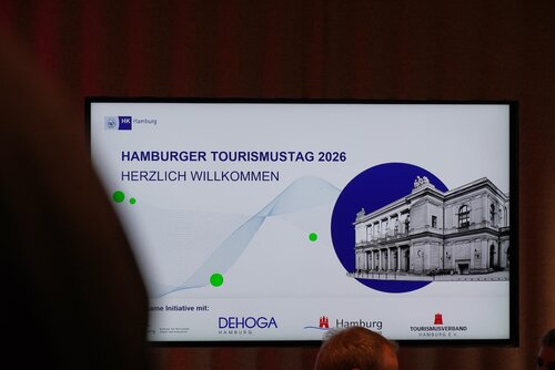 Bildschirmpräsentation zum Hamburger Tourismustag 2026 mit Willkommensnachricht.