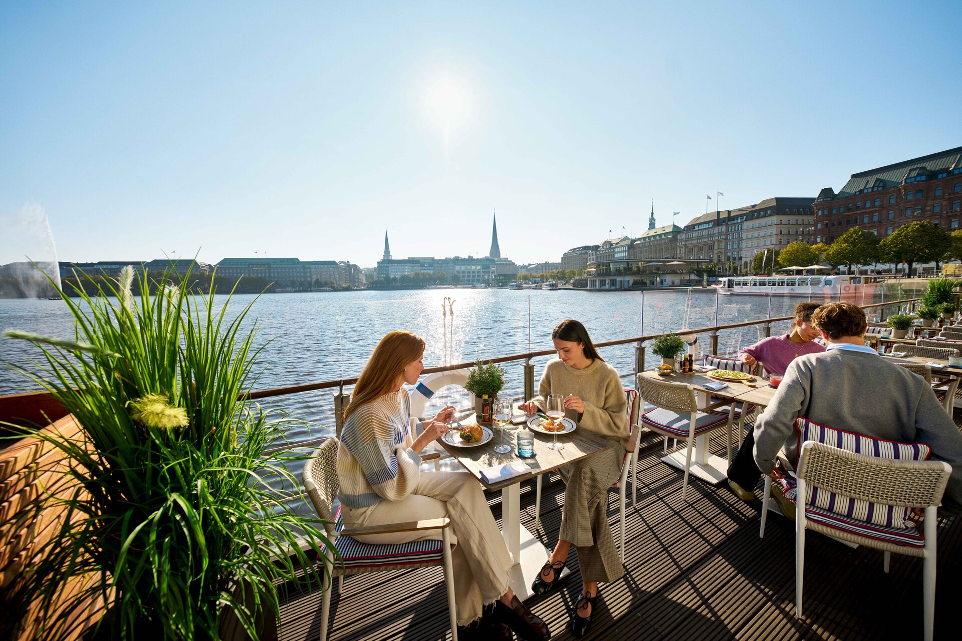 Menschen essen vor Alsterkulisse