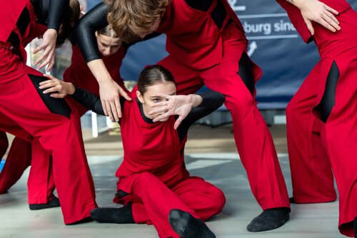 Eine Tanzgruppe in roten Kostümen, die eine dynamische Pose einnimmt. Impressionen vom Bürgerfest zum Tag der Deutschen in Bremen.