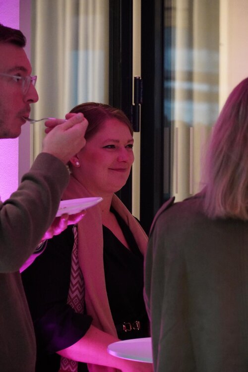 Menschen bei einem Event, Essen und Gespräche in Hintergrundbeleuchtung.