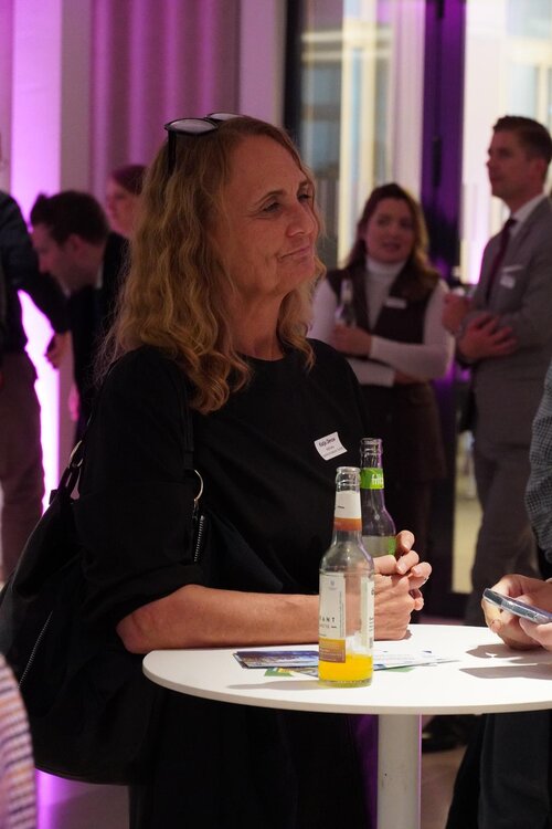 Eine Person mit Getränken an einem Tisch in einem Event.
